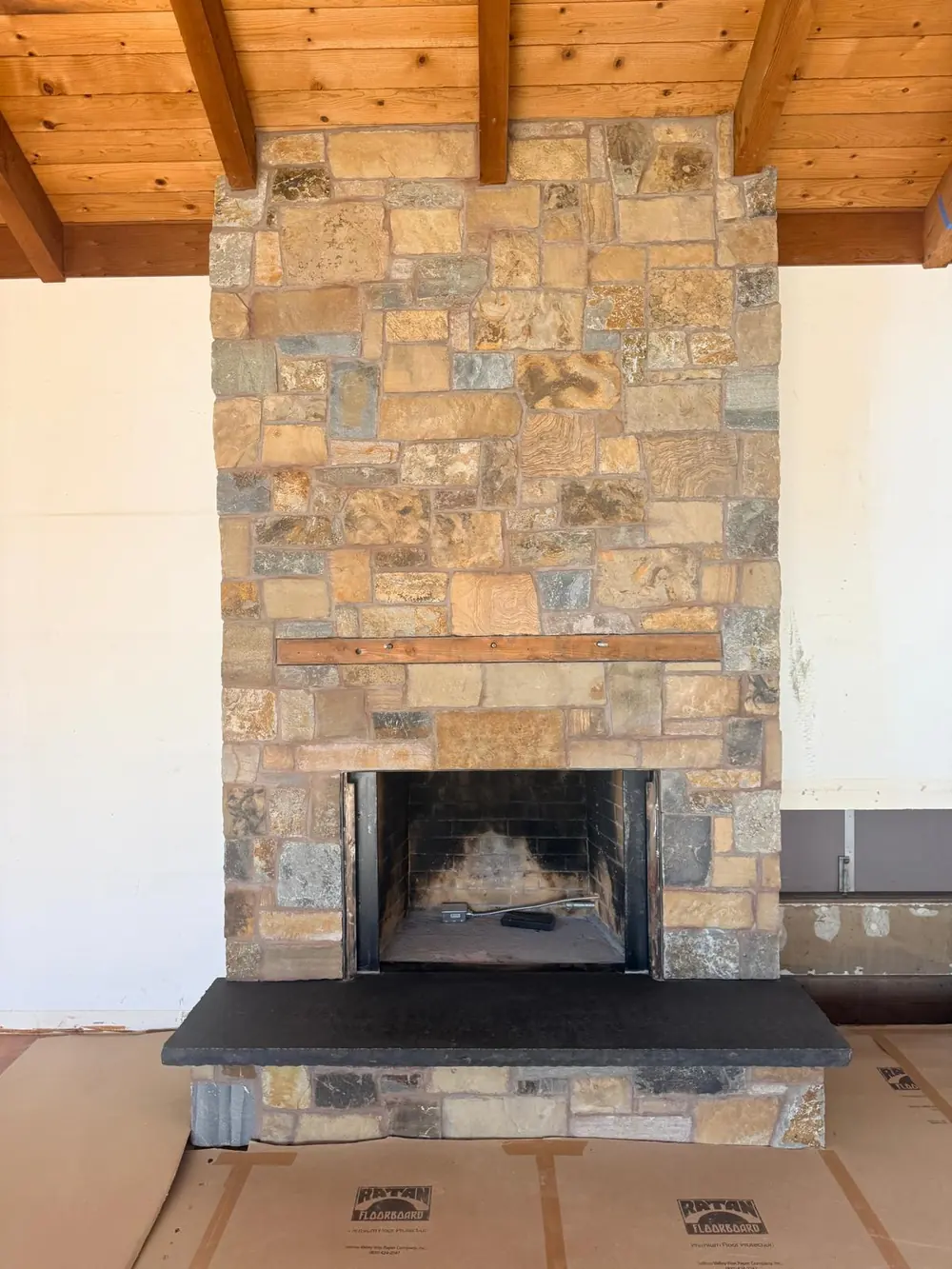 Floor-to-ceiling stone veneer fireplace