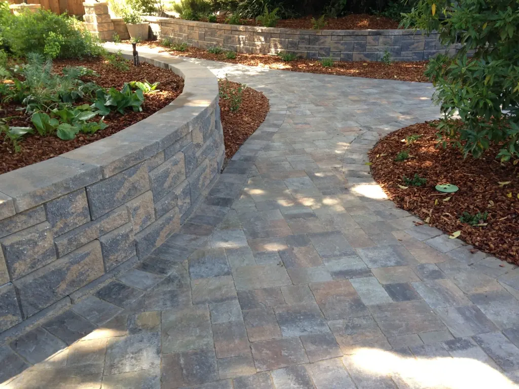 Curved paver walkway with a low block wall