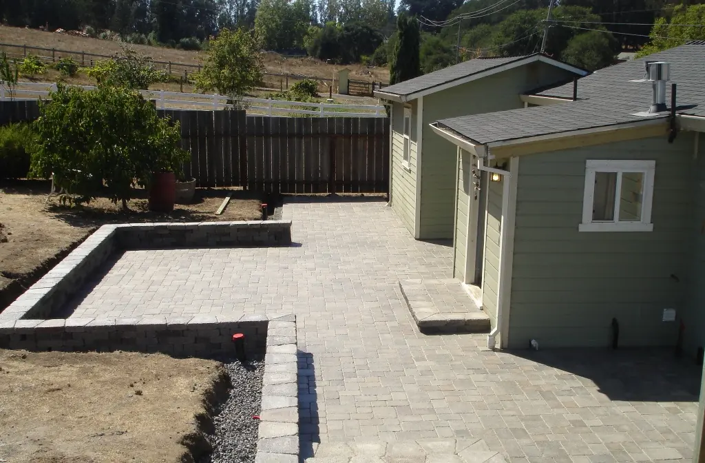 Paver patio beside a cottage