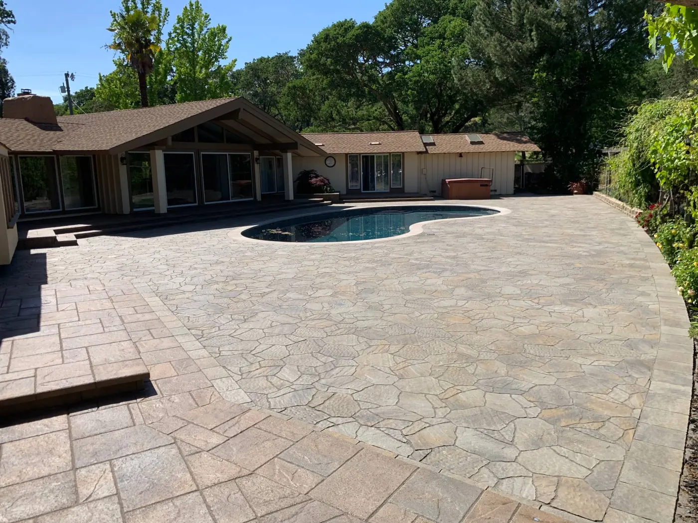 Paver pool deck around a kidney-shaped pool