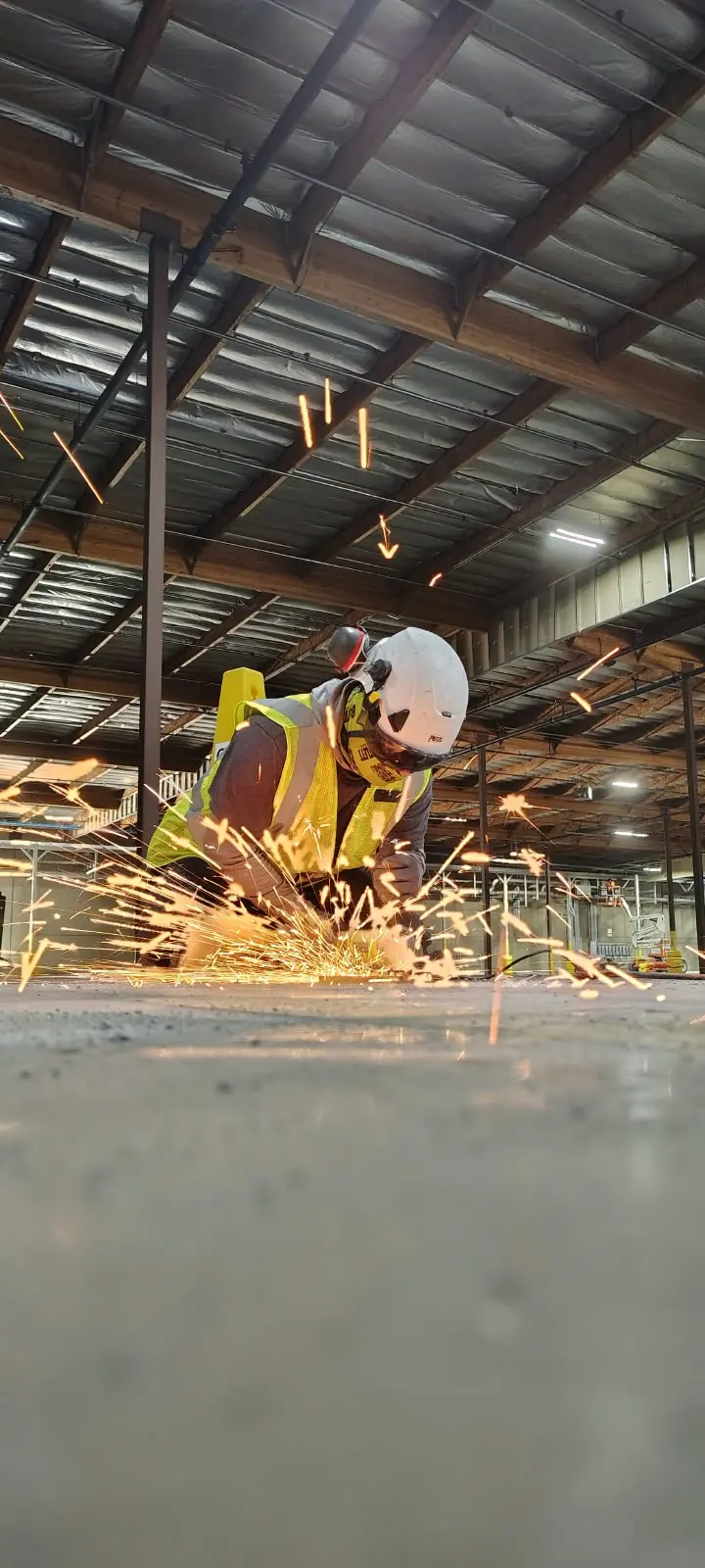 Fernandez Masonry crew member cutting material with sparks flying